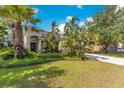 Expansive front yard with palm trees, lush greenery, and a well-manicured lawn leading up to the home at 12636 Hammock Pointe Cir, Clermont, FL 34711