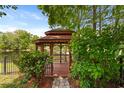 Outdoor gazebo with wood construction and scenic lake views with lush landscaping for shade and privacy at 14037 Fairway Willow Ln, Winter Garden, FL 34787