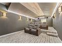 Home theater with tiered seating, sconce lighting, and a wood-paneled ceiling at 14037 Fairway Willow Ln, Winter Garden, FL 34787