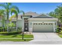 Charming single-story home with lush landscaping, mature palm trees, and a well-manicured lawn at 14137 Queenside St, Orlando, FL 32824