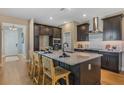 Modern kitchen boasts dark cabinets, a spacious island with seating, and stainless steel appliances at 15201 Summer Harvest St, Winter Garden, FL 34787