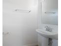 Clean half bathroom with a pedestal sink, a mirror, and a towel rack at 2294 Canyon Breeze Ave Ave, Kissimmee, FL 34746