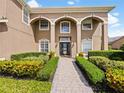 Elegant home entrance with a paved walkway and beautifully manicured landscaping at 2365 Sterling Creek Pkwy, Oviedo, FL 32766
