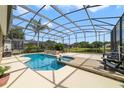 Inviting screened-in pool and patio area with a spa overlooking the tranquil lake at 2787 Cypress Head Trl, Oviedo, FL 32765