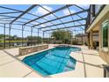 Relaxing screened-in pool with spa, water feature, brick bar, and serene lake views for outdoor enjoyment at 2787 Cypress Head Trl, Oviedo, FL 32765