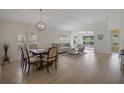 Bright dining room featuring hardwood floors, white walls, modern lighting, and a seamless open floor plan at 3018 Andover Ct, Mount Dora, FL 32757