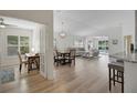 Bright living space featuring hardwood floors, white walls, modern lighting, and a seamless open floor plan at 3018 Andover Ct, Mount Dora, FL 32757