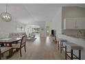 Bright open-plan space featuring hardwood floors, white walls, modern lighting and seamless transition to the living room at 3018 Andover Ct, Mount Dora, FL 32757