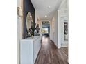 Inviting hallway with wood floors, decorative console table, and stylish lighting at 3121 Partington Blvd, Davenport, FL 33837
