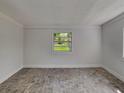 Neutral bedroom with a large window offering backyard views and tile floors at 3220 Mahalia Pl, Orlando, FL 32805