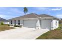 Charming single-story home featuring a spacious driveway and a three-car garage at 4743 Sw 114Th Pl, Ocala, FL 34476
