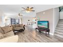 Bright living room with wood-look floors leading to a kitchen and screened patio at 4801 Apple Blossom Ln, St Cloud, FL 34771
