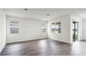 Spacious living room featuring wood-look floors, bright windows, and sliding glass doors to outdoor space at 5227 Ligonberry St, Lakeland, FL 33811