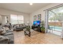 Open-concept living area with natural lighting, neutral furniture, and a view of the screened-in pool at 550 Las Fuentes Dr, Kissimmee, FL 34746