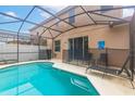 Backyard view of the screened-in pool with lounge chairs and secure pool fencing at 550 Las Fuentes Dr, Kissimmee, FL 34746