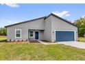 Charming single-story home with a blue front door and attached two-car garage at 5835 Sw 154 Lane Rd, Ocala, FL 34473