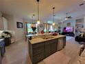 Open kitchen with a large island, stainless steel appliances, and open floor plan at 603 Sanctuary Golf Pl, Apopka, FL 32712