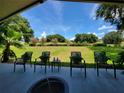 Relaxing outdoor patio with furniture overlooking the green backyard and blue sky at 603 Sanctuary Golf Pl, Apopka, FL 32712