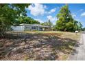 Charming single-story house with a covered front porch, well-maintained lawn and mature trees at 6124 Bear Lake Ter, Apopka, FL 32703