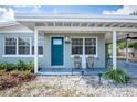 Inviting front porch with seating, a vibrant blue door, and decorative landscaping at 6124 Bear Lake Ter, Apopka, FL 32703
