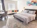 Cozy bedroom featuring a stylish bed, colorful pillows, and a comfortable seating area near the window at 6165 Carrier Dr # 2308, Orlando, FL 32819