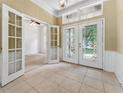 Bright foyer features tile flooring, decorative glass double doors, and transom windows at 6550 Crestmont Glen Ln, Windermere, FL 34786