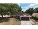 Inviting single-Gathering home with attached garage and mature landscaping, showcasing curb appeal at 7700 Greytwig Ln, Orlando, FL 32818