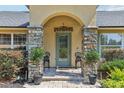 Inviting front entrance with a stone pillar entryway and meticulously maintained landscaping at 7779 Lake Andrea Cir, Mount Dora, FL 32757