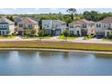 A picturesque view of a modern community with stunning homes along a serene lake at 2009 Tropical Palms Cir, Kissimmee, FL 34747