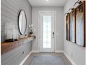 Inviting foyer with decorative wall paneling, stylish mirror and a patterned entrance rug at 2751 Matera Dr, St Cloud, FL 34771