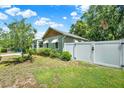 Side yard with white fence offering privacy, lush green lawn, and attractive landscaping at 508 10Th St, St Cloud, FL 34769