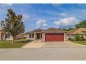 Charming single-story home features a well-maintained lawn and a striking red two-car garage door at 50989 Highway 27 # 371, Davenport, FL 33897