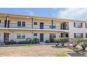 Exterior view of a two-story condo featuring balconies, trimmed bushes, and tidy landscaping around the front entrance at 5505 Hernandes Dr # 204, Orlando, FL 32808