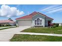 Charming single-story home with a red tile roof, well-manicured lawn, and an attached two-car garage at 751 Via Milano, Apopka, FL 32712