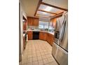 Charming kitchen featuring light wood cabinetry, stainless steel appliances, tile flooring, and a bright window view at 76 Oakdale St, Windermere, FL 34786