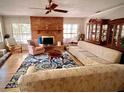 Cozy living room with a brick fireplace, wood floors, large patterned rug, and inviting seating arrangement at 76 Oakdale St, Windermere, FL 34786