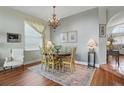 Formal dining room featuring chandelier lighting, wood flooring, and large window at 9915 Kona Isle Ct, Orlando, FL 32817