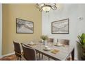 An elegantly furnished dining room features a granite table, chandelier, and decorative artwork at 9915 Kona Isle Ct, Orlando, FL 32817
