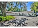 A large one-story home with a three-car garage and a paved driveway surrounded by lush greenery at 1003 Shore Dr, Kissimmee, FL 34744