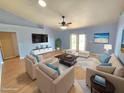 Stylishly staged living room features modern furniture, light blue walls, and sliding glass doors for seamless indoor-outdoor living at 10235 Summer Elm Ave, Clermont, FL 34711
