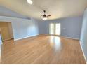 Spacious living room with light blue walls and wood flooring offers a blank canvas for creating a comfortable living space at 10235 Summer Elm Ave, Clermont, FL 34711