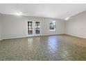 Spacious living room with ceramic floors, ceiling fans and French doors at 12610 Bay Hill Dr, Grand Island, FL 32735