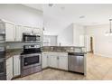 Modern kitchen with stainless steel appliances, granite countertops, and a view into the living area at 13489 Sw 60Th Avenue Rd, Ocala, FL 34473