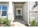 Charming entryway with brick-paved walkway, a wreath on the door, and lush green landscaping at 13617 Haulover Beach Ln, Orlando, FL 32827