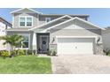 Inviting two-story home with a brick-paved driveway, two-car garage, and a manicured front yard at 13617 Haulover Beach Ln, Orlando, FL 32827