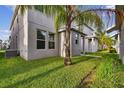 The spacious backyard features manicured grass, a palm tree, and well maintained exteriors at 15210 Chapter Way, Winter Garden, FL 34787