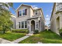 Charming two-story home featuring a stone archway entry and lush green lawn at 15210 Chapter Way, Winter Garden, FL 34787