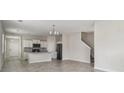Open-concept living space features tile floors, a kitchen, and a staircase at 15210 Chapter Way, Winter Garden, FL 34787
