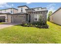 Beautiful two-story home with stone accents, a two-car garage and lush green lawn at 1539 Wynell St, St Cloud, FL 34771
