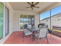 Covered patio with a dining table, chairs, ceiling fan, and a grill at 16078 St Clair St, Clermont, FL 34714
